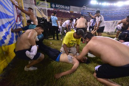 Fanáticos auxilian a personas durante una estampida en el Estadio Cuscatláán previo a un partido de la Liga Mayor, en San Salvador (El Salvador).