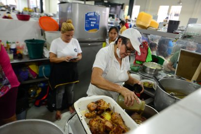 Mientras Ana  Julia sazona el almuerzo, su hija se encarga de contactarse con los clientes por celular.