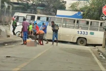 Momento en que un grupo de sujetos se acercó al cuerpo y uno de ellos le sacó objetos de un bolsillo del pantalón.