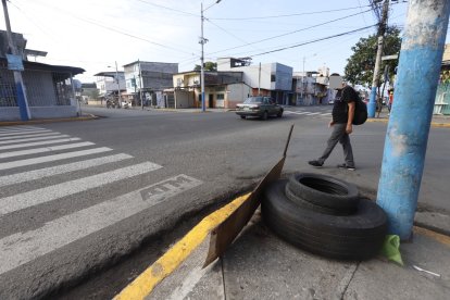 El cuerpo quedó sentado junto a un poste, en el que hay llantas para promocionar el servicio de la vulcanizadora en la que trabajaba.