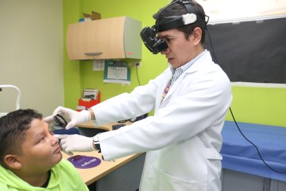 El doctor Edwin Villacís revisa el estado de los ojos a un menor de edad.