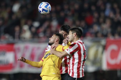 Luciano Lollo (d) y Santiago Núñez (atrás) de Estudiantes disputan el balón con Francisco Fydriszewski (i) de Barcelona.