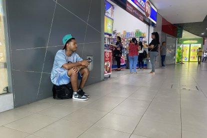 Steven Burbano, quien esperaba a alguien dentro del terminal, prefirió sentarse encima de su maleta.