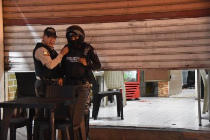 Dos policías custodían el acceso al lugar donde acribillaron a un abogado, mientras comía junto a un amigo.