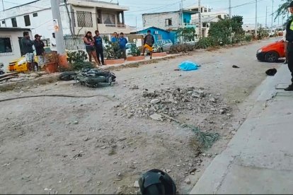 La moto volcada y las dos personas ensangrentadas en la calle.
