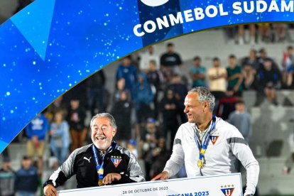Issac Álvarez presidente de Liga de Quito y Esteban Paz sostienen el premio por ganar ls final.