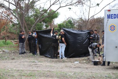 Los cuerpos estaba a un costado de la vía. Con fundas plásticas policías cubrían el procedimiento.