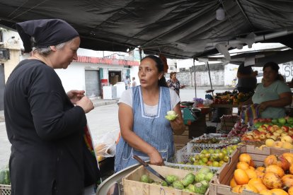 Si es necesario, Doña Nelly hace probar a sus clientes las frutas que ofrece en su puesto.