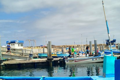 Los familiares de los pescadores se muestran angustiados al pie del muelle.