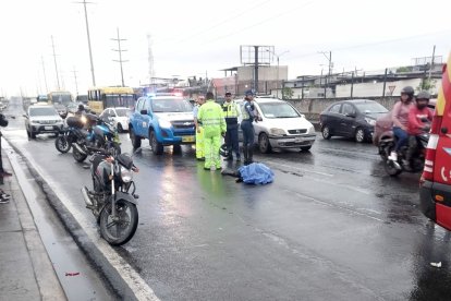 El cuerpo quedó sobre la calzada mojada. El fallecido sería el conductor de la motocicleta.