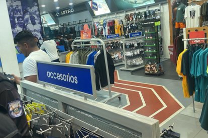 Policías llegar hasta la tienda deportiva asaltada para recabar indicios.