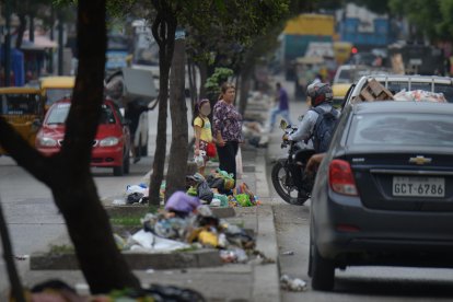 Personas intentando cruzar en medio de una fila de desechos en el parterre de la Av. Modesto Luque.
