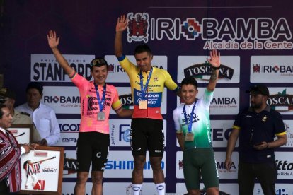 Jhonatan Narváez celebra en el podio con Richard Carapaz dando un mordisco al hornado riobambeño.