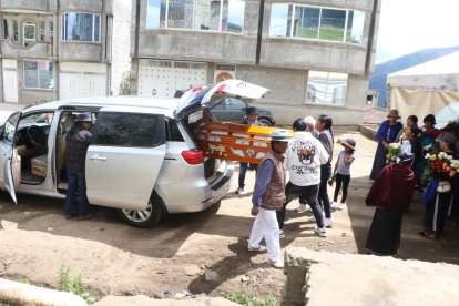 La gente saca el féretro de la casa donde fue velado para luego llevarlo hasta el cementerio local.