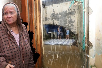 Doña Zoila Montes Cedeño (centro) recibe al apoyo de sus vecinos. A un costado están sus electrodomésticos dañados.