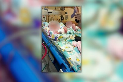 En esta imagen proporcionada por el Cuerpo de Bomberos de Quito se observa a la madre y sus gemelos en la cama de un hospital.