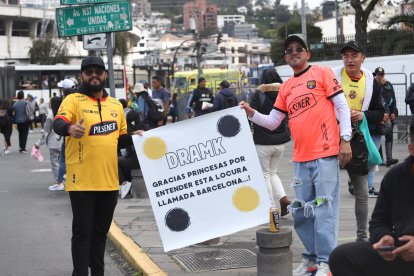 El hincha Esteban Bermúdez (i) con el cartel para su esposa e hijos.