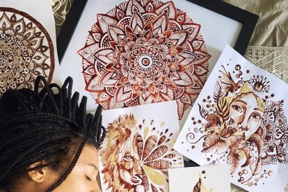 Jasmine Carter junto a algunas de sus pinturas hechas con su período.