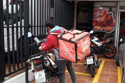 Los repartidores esperan por los pedidos en las aceras o en parques.