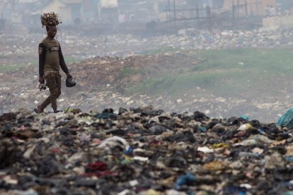 En la imagen de archivo, un hombre transporta cables sobre su cabeza en el vertedero de Agbogbloshie, un barrio de Accra, capital de Ghana, considerado el mayor vertedero de basura electrónica del continente Africano.