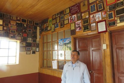 Miguel López muestra las decenas de placas que dejan los devotos.