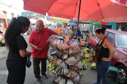 Breston explica a sus clientes lo que pueden usar en sus alimentos cada que llegan a su puesto.