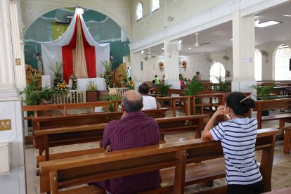 En el interior del Santuario del Cristo del Consuelo, en Guayaquil, los devotos oraban, mientras que fuera del templo alistaba todo para la procesión tradicional.