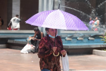Una ciudadana optó por usar una sombrilla para evitar recibir los rayos del sol.