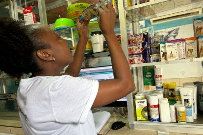 Una comerciante de una farmacia en Quinindé intenta detectar, exponiendo el billete a la contraluz, si este es falso o verdadero.