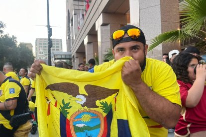 Michael Montaño, guayaquileño que reside en Los Ángeles desde hace más de 5 años, besa con fervor la bandera ecuatoriana afuera de uno de los estadios que albergan la Copa.