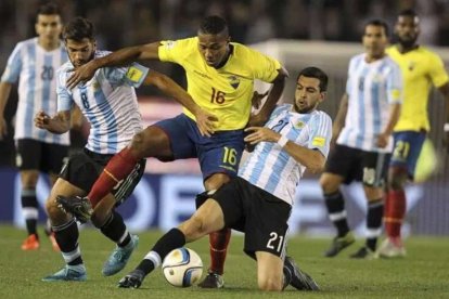 Antonio Valencia (c) ante la marca de dos argentinos en la victoria 2-1 de 2015