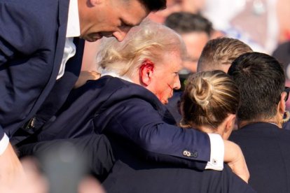 Momento exacto en que Donald Trump trata de cubrirse de las balas.