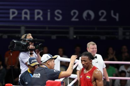 El boxeador José es atendido en la esquina por su entrenador en su debut olímpico