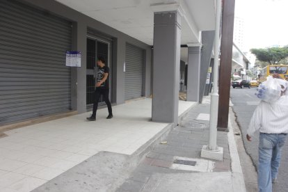 Ciudadano observa el sello de clausura de Worldcoin en Guayaquil.