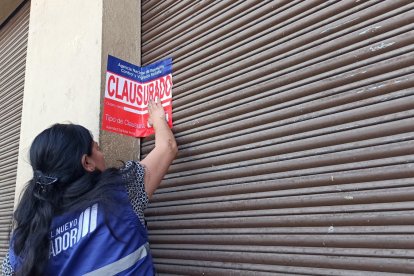 Referencial. Técnicos de la Arcsa clausurando un local comercial.