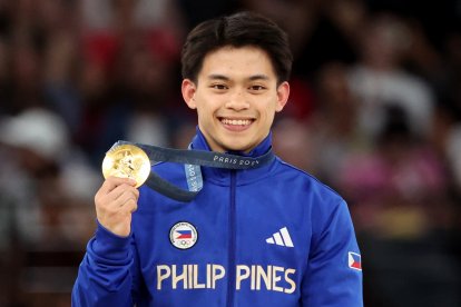 El ganador de la medalla de oro Carlos Edriel Yulo de Filipinas posa en el podio de la final de salto masculino de las competiciones de gimnasia artística en los Juegos Olímpicos de París 2024.