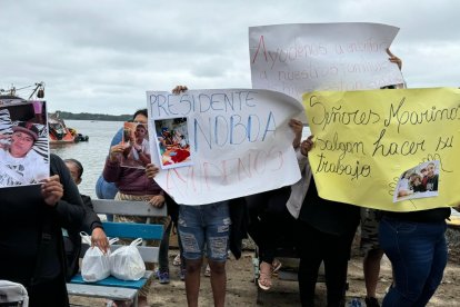 Familiares de desaparecidos, con carteles, piden que ayuden a buscar a sus parientes.