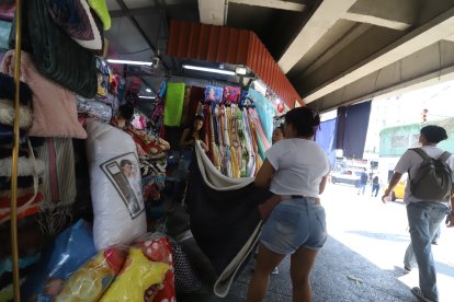 Dos ciudadanas en la Bahía de Guayaquil revisan el diseño, tamaño y material antes de comprar una manta para el frío.