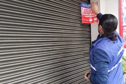 Referencial. Personal de la Arcsa clausurando un local comercial.
