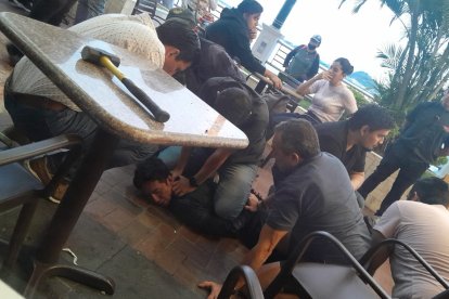 Varias personas sostienen al hombre que agredió a una mujer en Puerto Santa Ana.