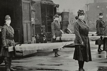 Personal de la Cruz Roja sostiene camillas durante la pandemia de la Gripe Española en 2018.