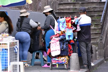 Algunas personas acceden a recibir un pago a cambio de un mechón, en las calles del Centro Histórico de Quito.