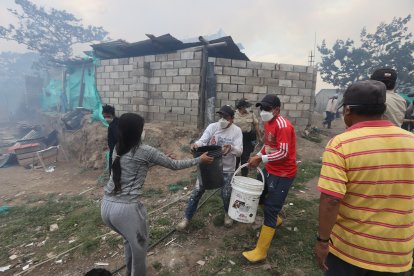 Habitantes intentan apagar el fuego y salvar sus hogares.