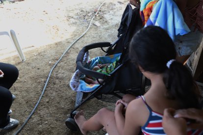 La niña contempla a su bebé en un pequeño coche. Ella le puso los nombres que más le gustaban.