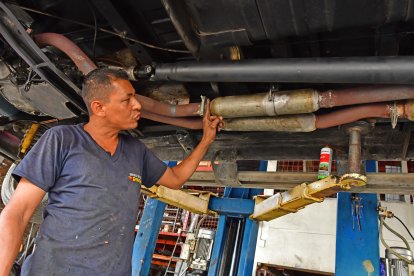 Mecánico revisa visualmente el estado del tubo de escape en busca de abolladuras o fisuras.