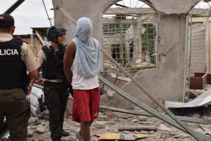 El detenido fue esposado y llevado a la zona del desastre.