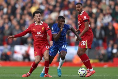 Moisés Caicedo y Curtis Jones disputan el balón.