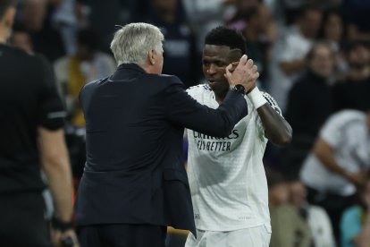 Vinícius Júnior (d) celebra el triplete de goles con el entrenador Carlo Ancelotti, durante el encuentro ante Borussia Dortmund en la Cahmpions League
