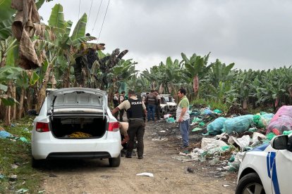 Elementos de la Policía Nacional custodian la escena donde se encontró a la víctima y los autos quemados.