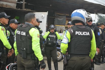 La mayor de la Policía Nacional Mayra Muñoz (c) es una de las tres féminas encargadas de la seguridad de la caravana de la Vuelta.